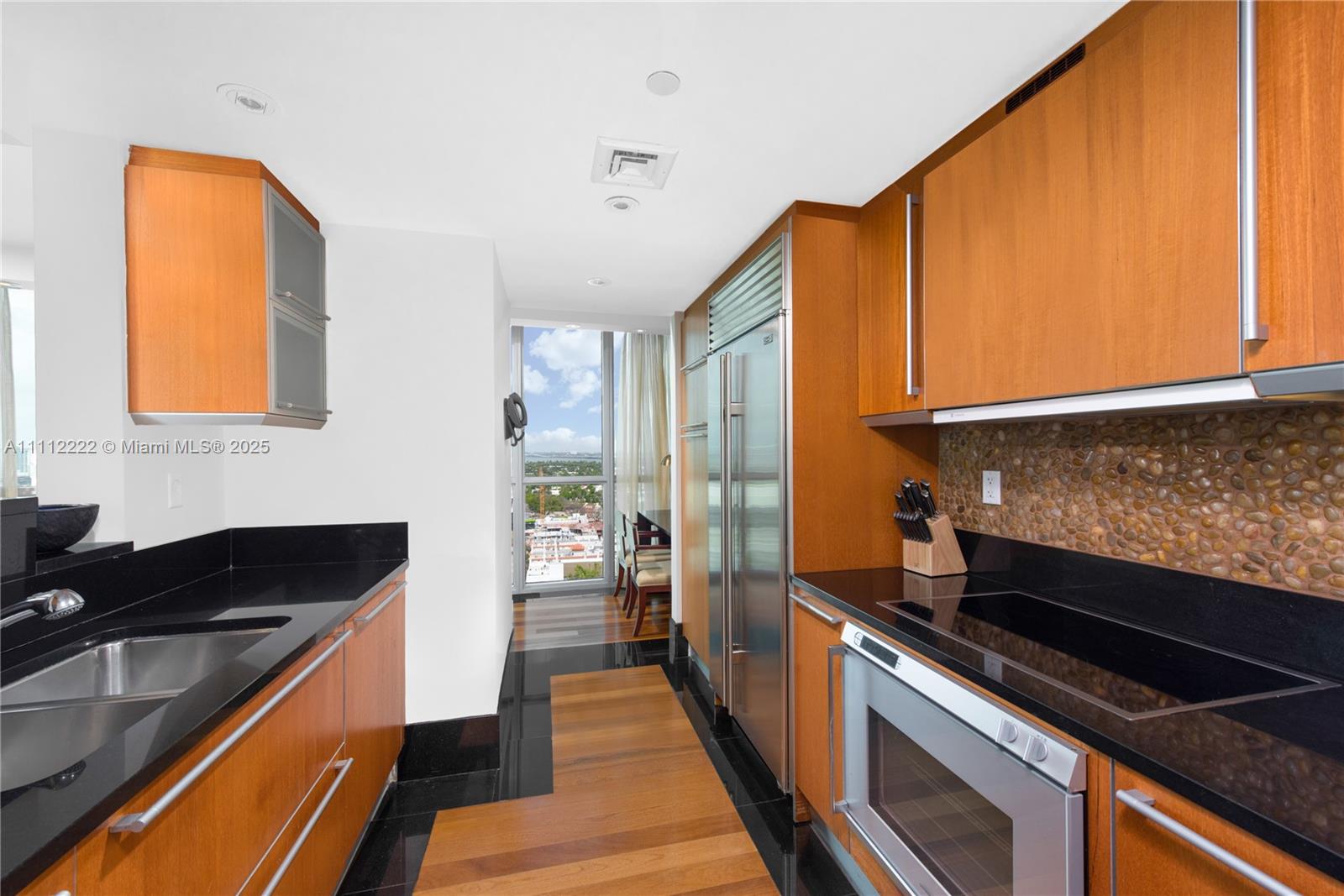 101 20th Street, Unit 2402 Miami Beach, FL 33139 - Photo 4 of 23 a kitchen with wooden cabinets and a stove top oven