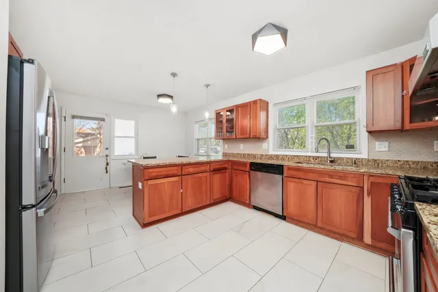 a kitchen with stainless steel appliances granite countertop a stove sink and cabinets