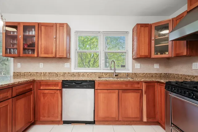 a kitchen with stainless steel appliances granite countertop wooden cabinets a sink and a stove