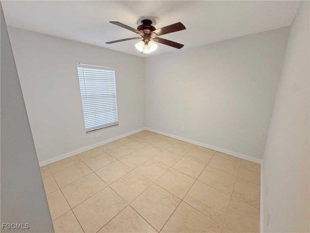 210 Manatee Street Fort Myers, FL 33913 - Photo 14 of 27 an empty room with chandelier fan and windows