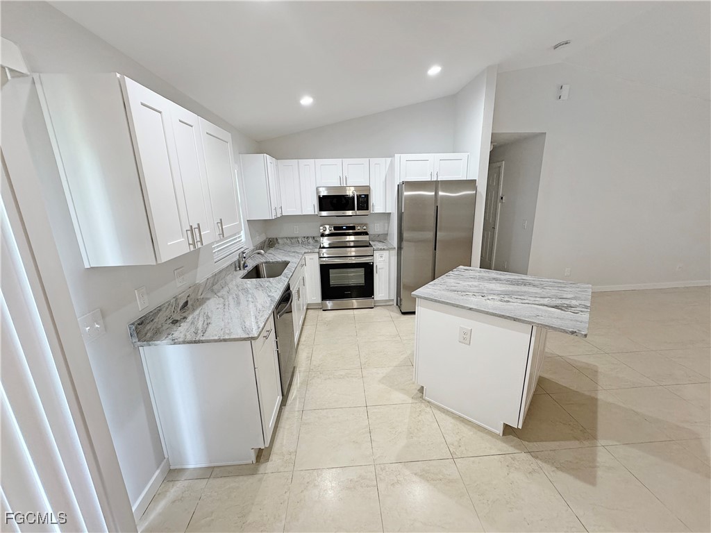 210 Manatee Street Fort Myers, FL 33913 - Photo 6 of 27 a kitchen with a sink a stove a refrigerator and cabinets