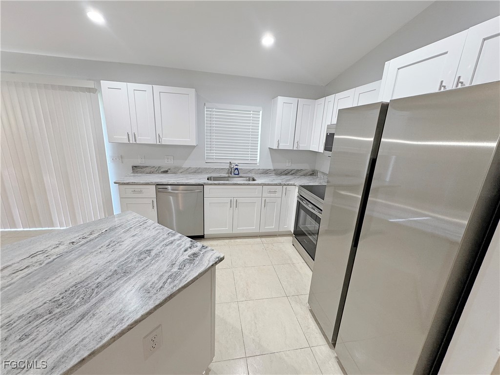 210 Manatee Street Fort Myers, FL 33913 - Photo 9 of 27 a kitchen with a sink a stove a refrigerator and cabinets
