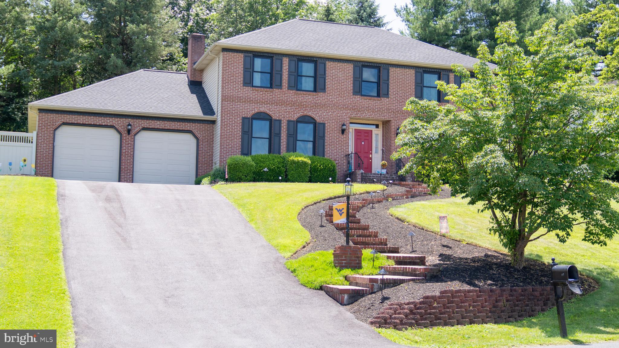 1042 Country Club Road Camp Hill, PA 17011 - Photo 2 of 41 a view of a white house with a swimming pool and lawn chairs under an umbrella