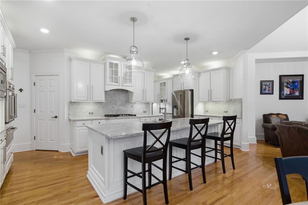 2058 Windermere Crossing Cumming, GA 30041 - Photo 18 of 75 a kitchen with kitchen island a stove a table and chairs in it