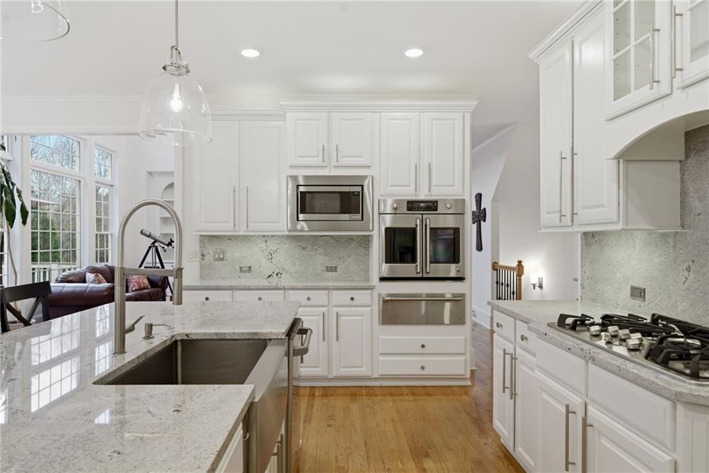 2058 Windermere Crossing Cumming, GA 30041 - Photo 21 of 75 a kitchen with white cabinets and stainless steel appliances