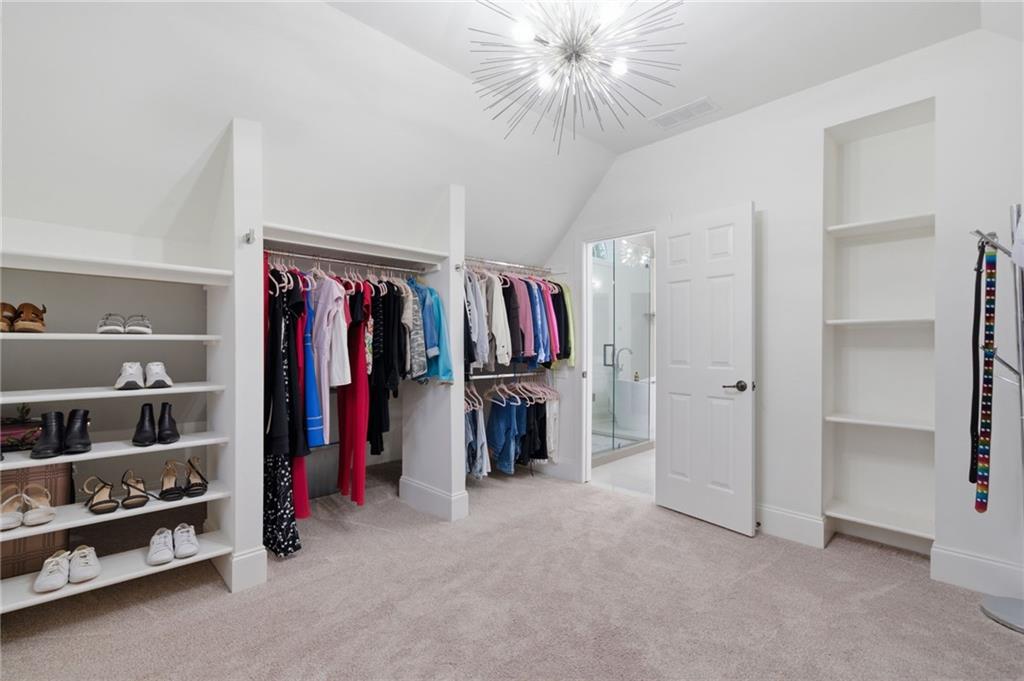 2058 Windermere Crossing Cumming, GA 30041 - Photo 42 of 75 a view of walk in closet with clothes and shoes