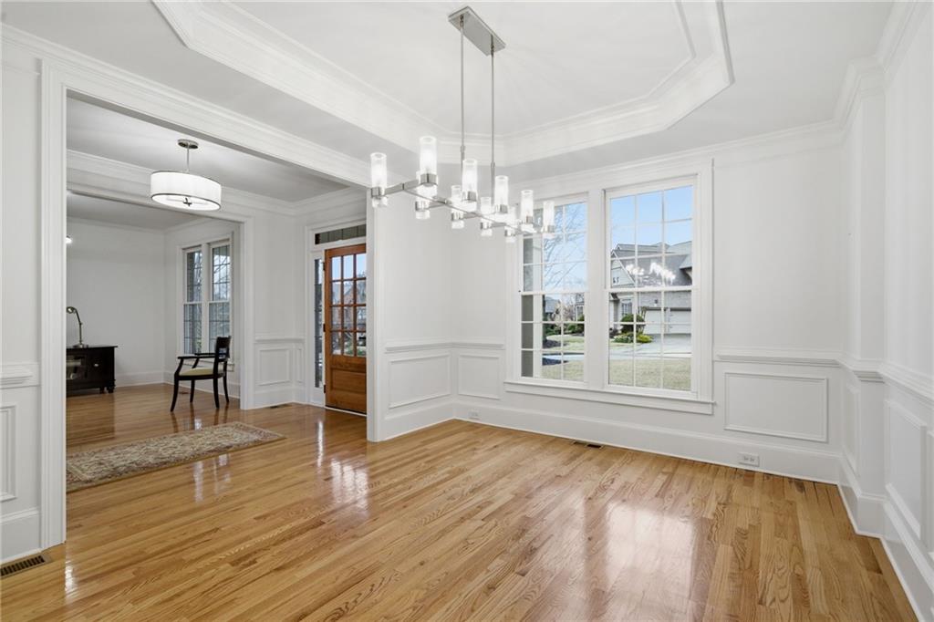 2058 Windermere Crossing Cumming, GA 30041 - Photo 7 of 75 a view of a livingroom with wooden floor and a kitchen space