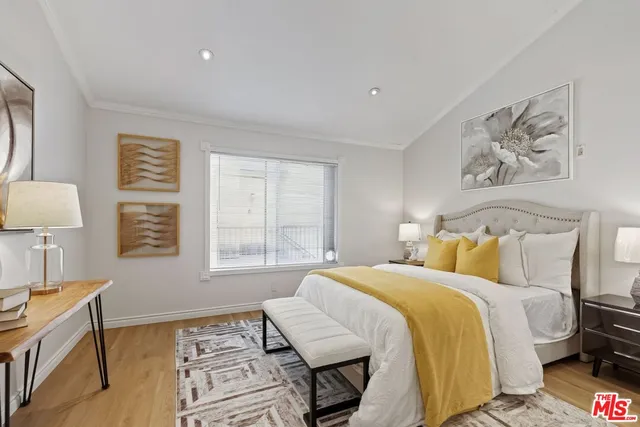 a bedroom with a bed and a lamp on dresser