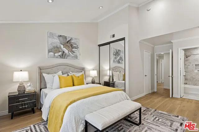 a bedroom with a bed and a painting on the wall