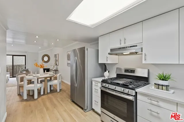 a kitchen with stainless steel appliances a white stove top oven and a refrigerator