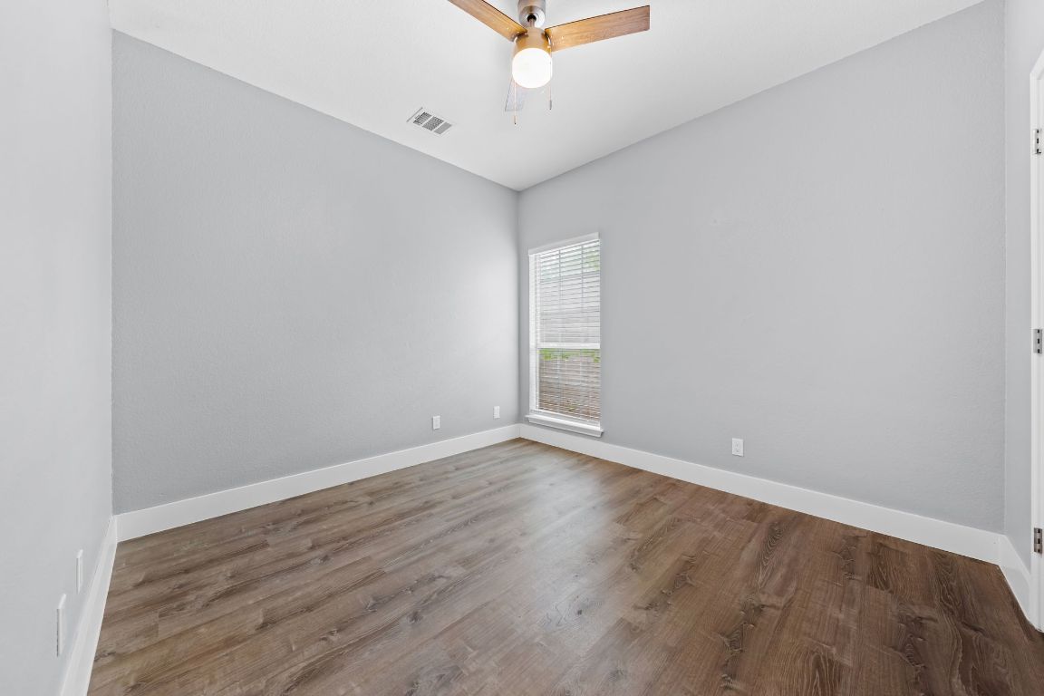 1214 Vargas Road, Unit A Austin, TX 78741 - Photo 16 of 25 Empty room with wood finished floors and a ceiling fan
