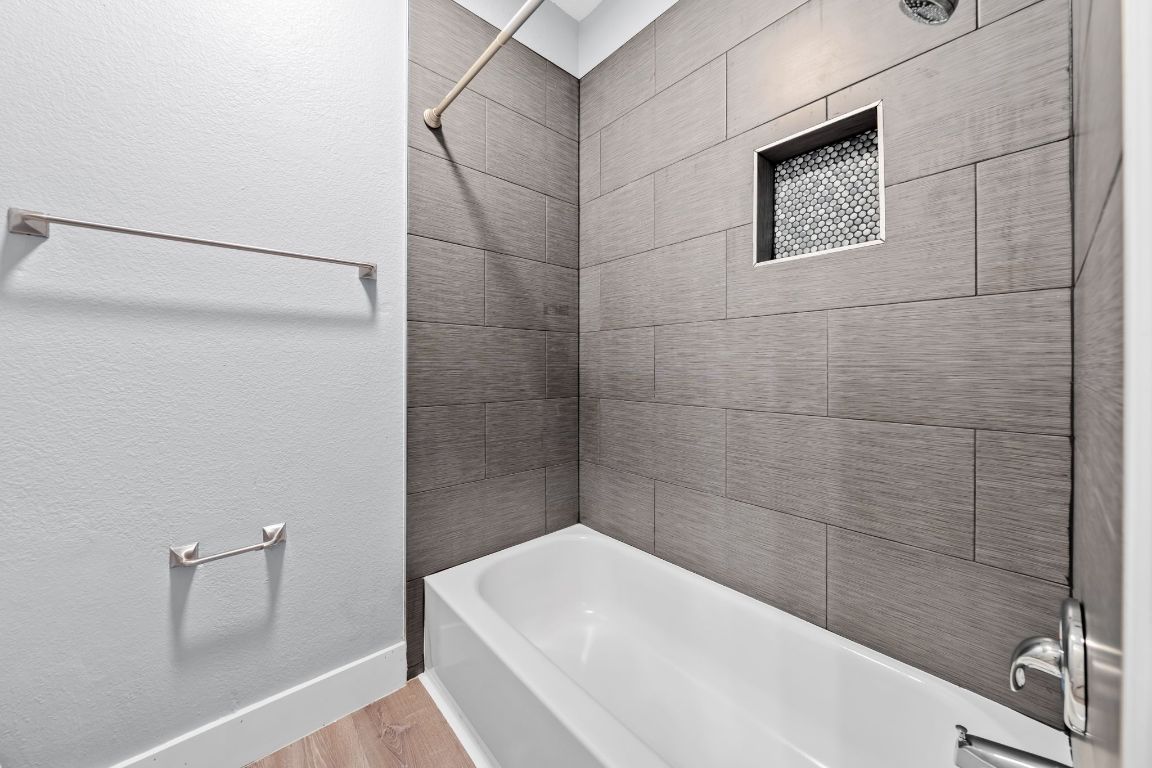1214 Vargas Road, Unit A Austin, TX 78741 - Photo 19 of 25 Full bathroom with a textured wall, shower / bath combination, and wood finished floors