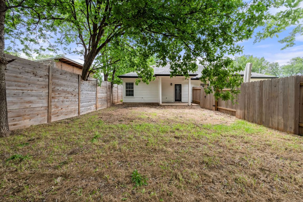 1214 Vargas Road, Unit A Austin, TX 78741 - Photo 24 of 25 Back of property with a patio, a fenced backyard, and roof with shingles