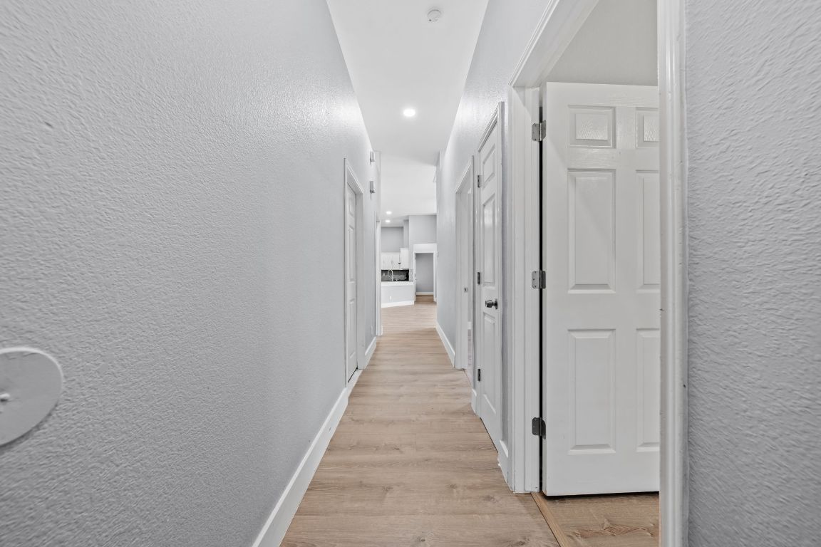 1214 Vargas Road, Unit A Austin, TX 78741 - Photo 5 of 25 Hallway featuring a textured wall and light wood finished floors