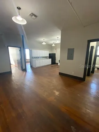 a view of a room with wooden floor and chandelier
