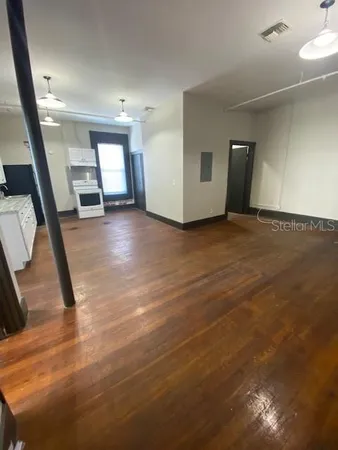 a view of a livingroom with wooden floor and stairs