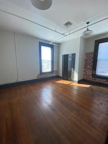 a view of a livingroom with wooden floor and a window