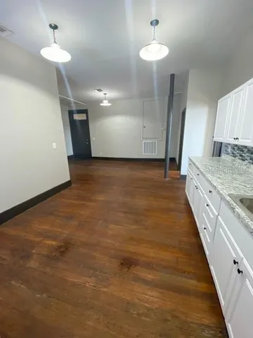 wooden floor in an empty room with a sink