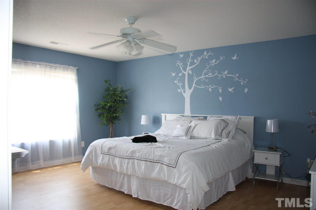 3136 Varcroft Road Knightdale, NC 27545 - Photo 16 of 23 a bedroom with a large bed and a chandelier