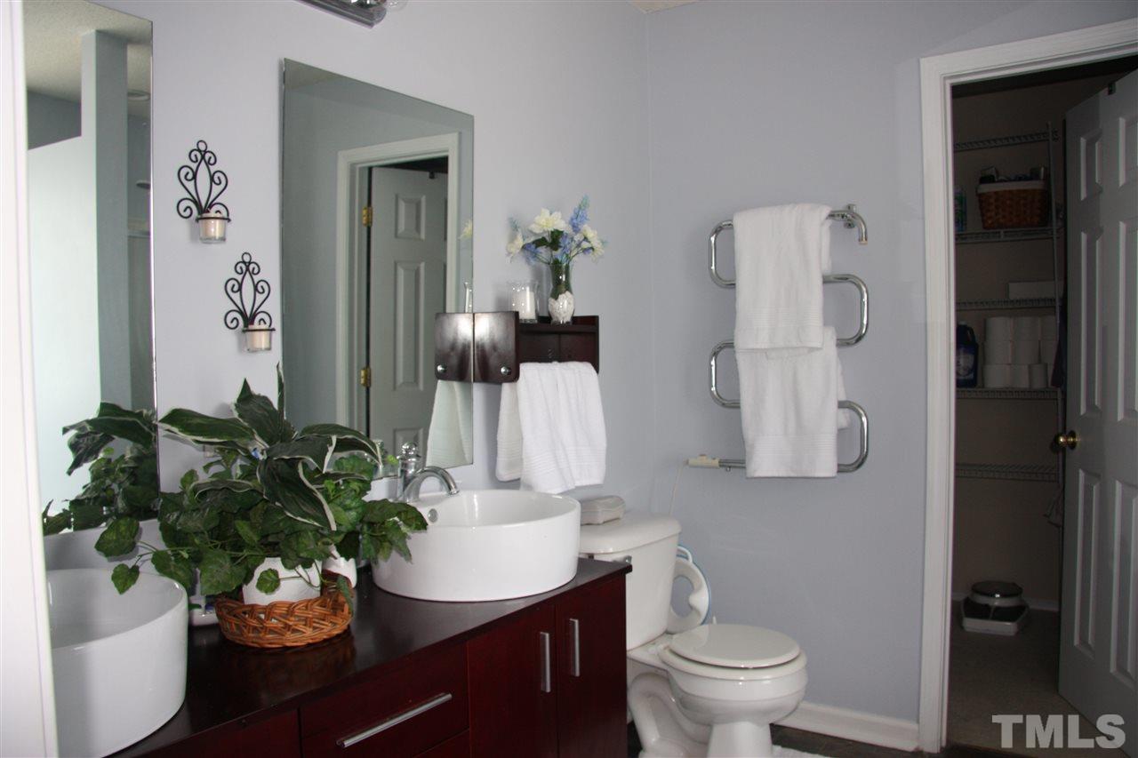 3136 Varcroft Road Knightdale, NC 27545 - Photo 18 of 23 a bathroom with a sink a toilet and a mirror