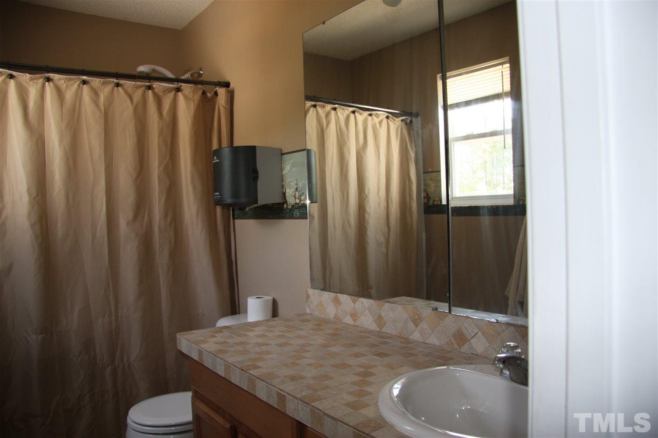 3136 Varcroft Road Knightdale, NC 27545 - Photo 20 of 23 a bathroom with a sink and a mirror