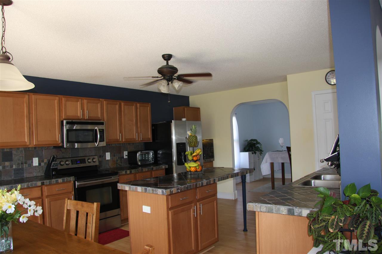 3136 Varcroft Road Knightdale, NC 27545 - Photo 9 of 23 a kitchen with stainless steel appliances granite countertop a sink a stove top oven a counter space and cabinets