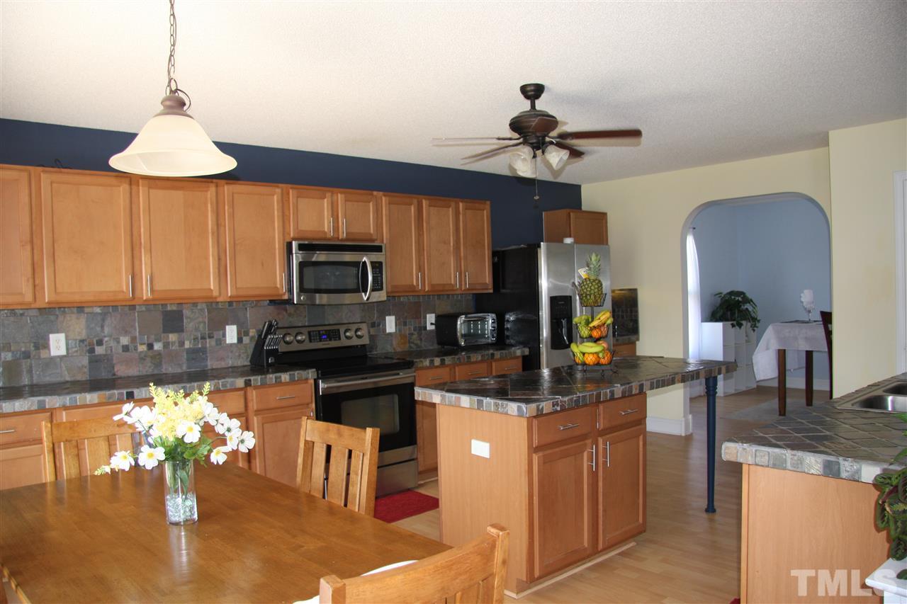 3136 Varcroft Road Knightdale, NC 27545 - Photo 10 of 23 a kitchen with kitchen island granite countertop a stove top oven a sink a counter space and cabinets