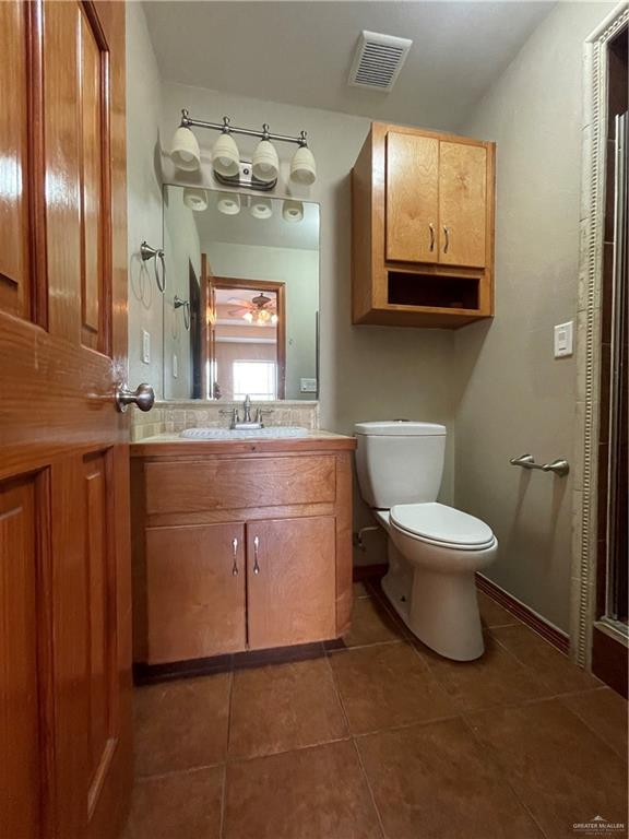 1305 East Olympia Avenue, Unit A McAllen, TX 78503 - Photo 11 of 13 a bathroom with a toilet sink and mirror