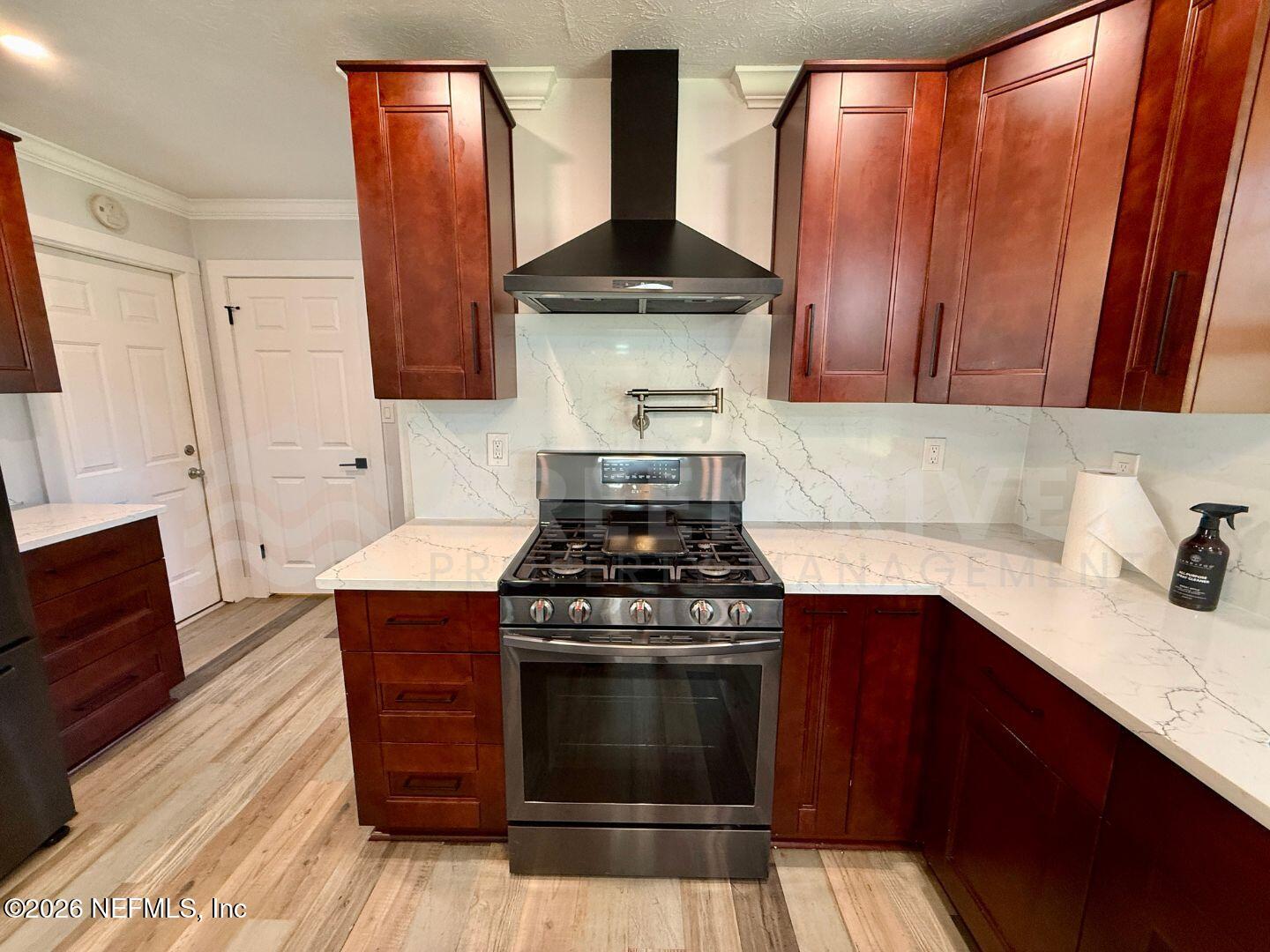 2 Fairway Road Jacksonville Beach, FL 32250 - Photo 17 of 39 a kitchen with granite countertop a stove top oven cabinetry a sink and a refrigerator