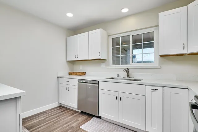 a kitchen with white cabinets and sink