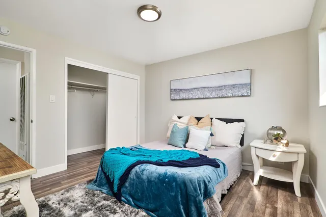a bedroom with a bed and wooden floor