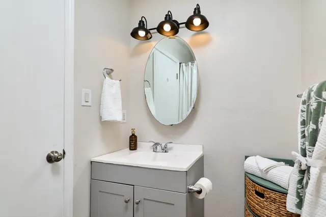 a bathroom with a sink a light fixture and a mirror