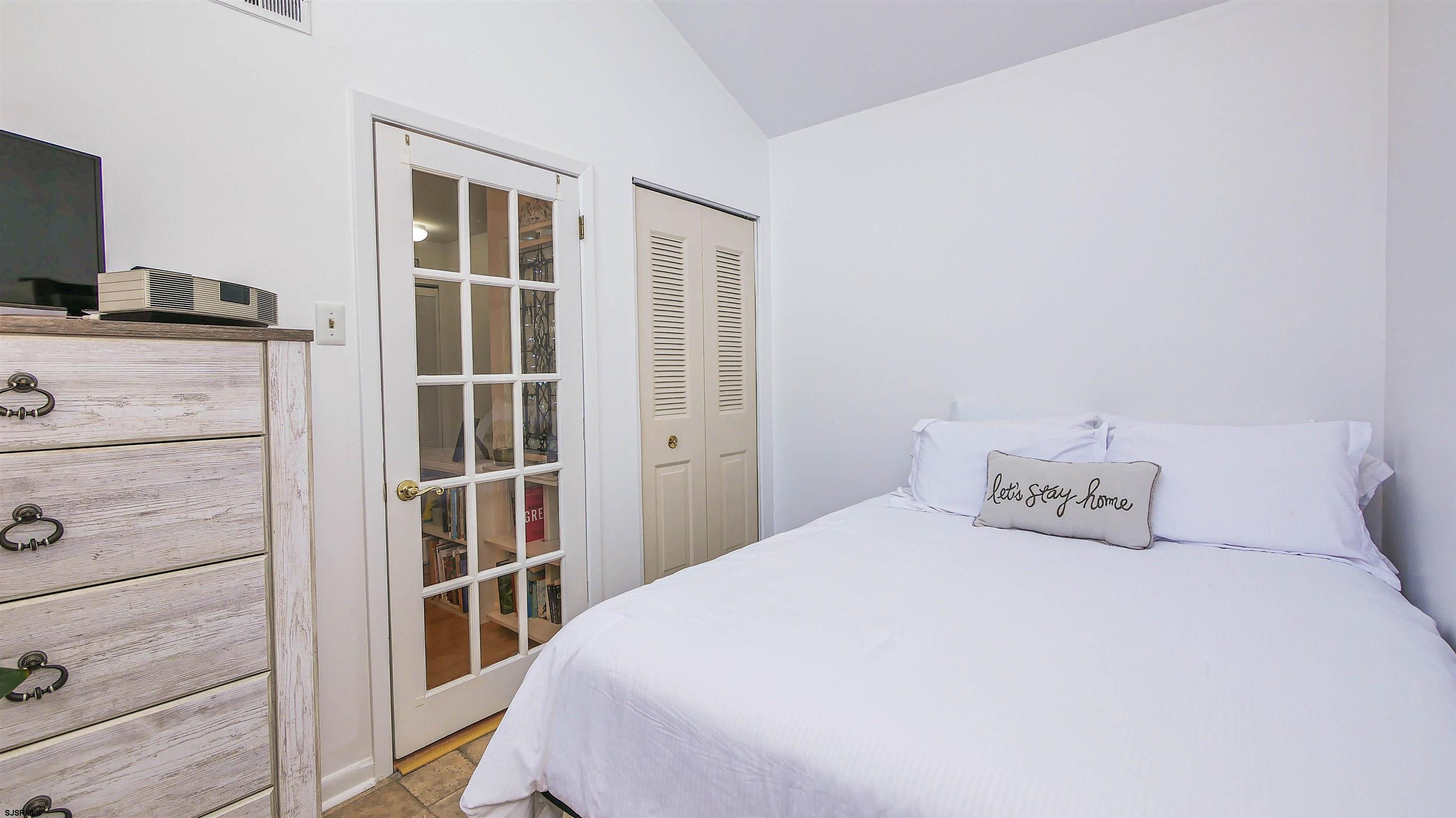 11 Shore Road, Unit 4G Somers Point, NJ 08244 - Photo 23 of 34 a bedroom with a bed and a flat tv screen on dresser