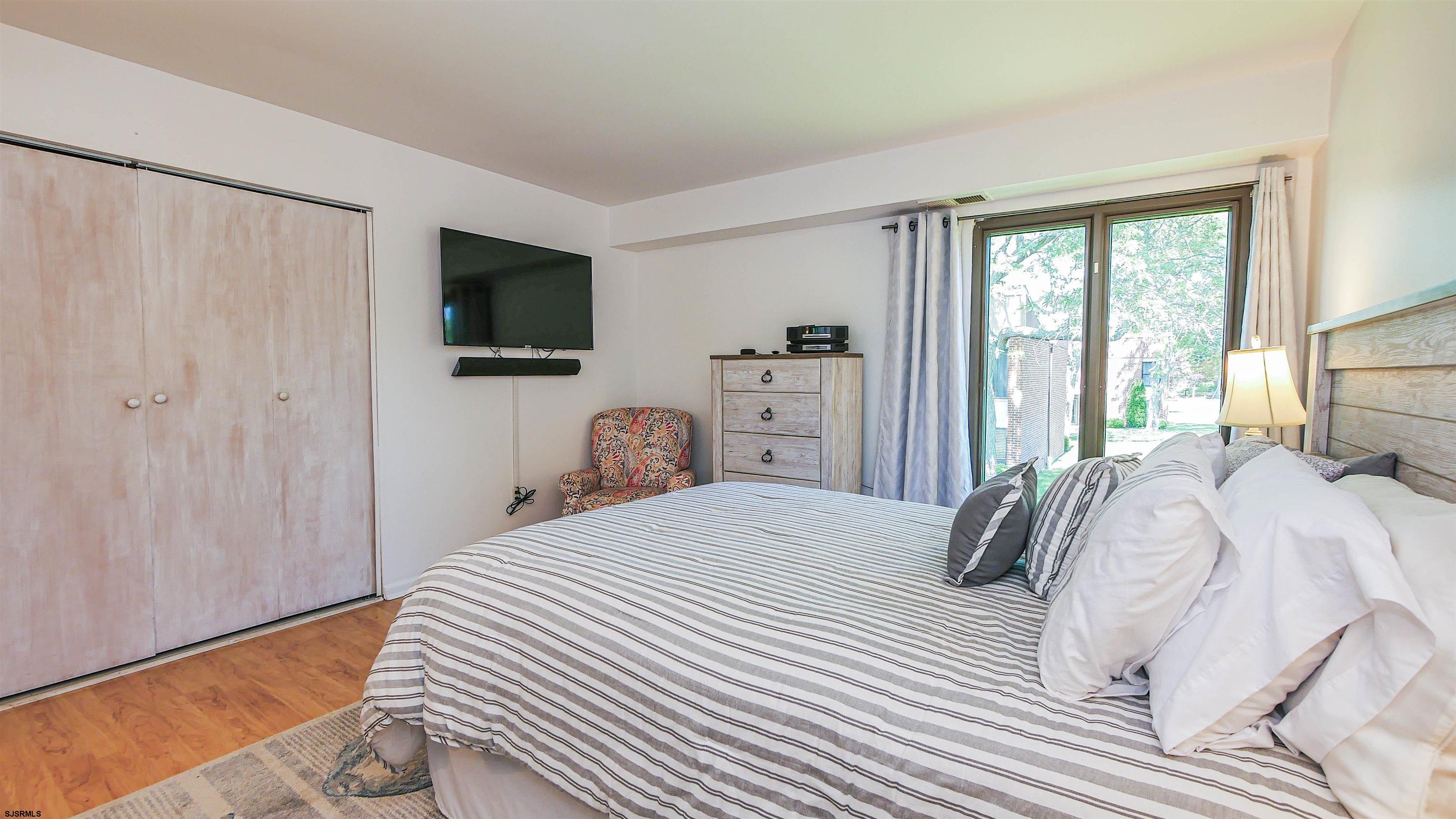 11 Shore Road, Unit 4G Somers Point, NJ 08244 - Photo 25 of 34 a bedroom with a bed and a flat screen tv