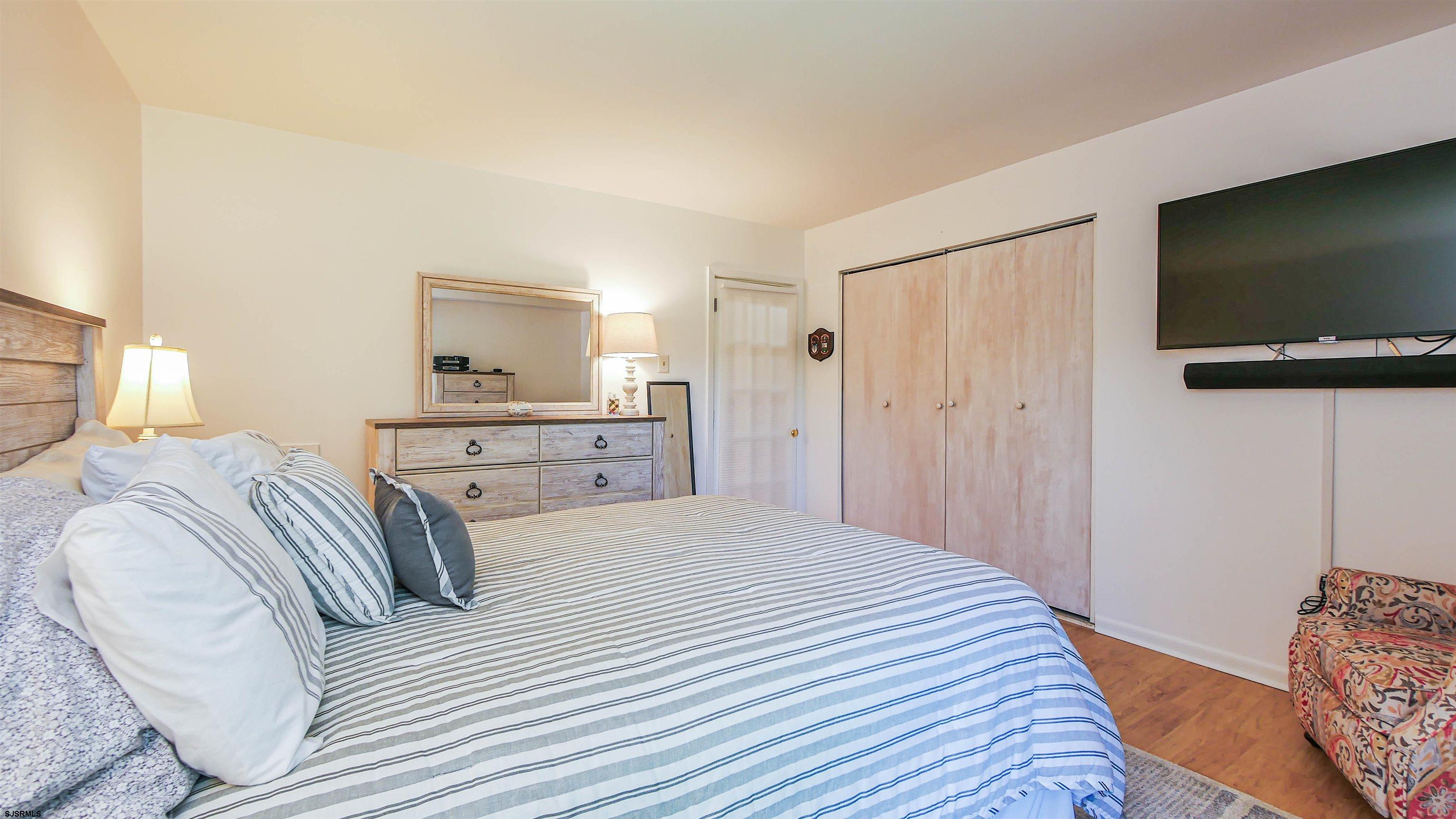 11 Shore Road, Unit 4G Somers Point, NJ 08244 - Photo 26 of 34 a bedroom with a bed and a flat screen tv