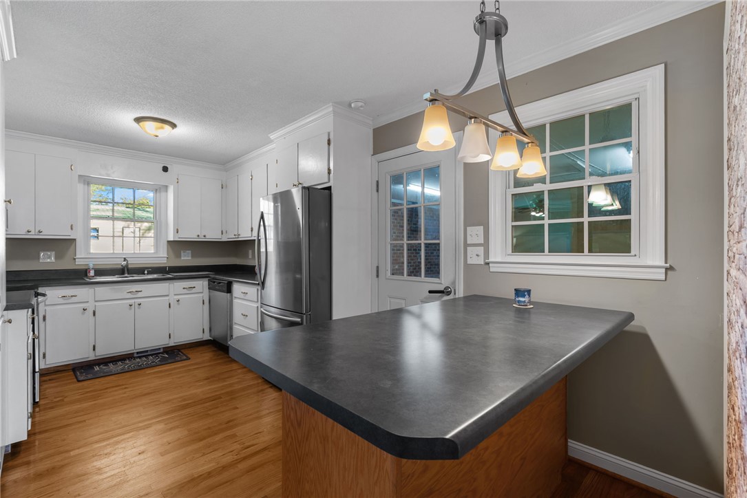 300 Green Street Williamston, SC 29697 - Photo 9 of 47 This bright kitchen features wood flooring and a convenient island, perfect for casual dining and entertaining.