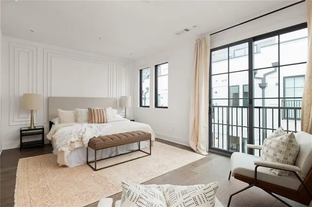 a bedroom with a bed and large windows