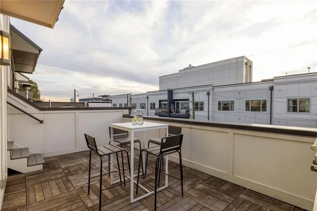 an aerial view of a house with balcony and outdoor seating