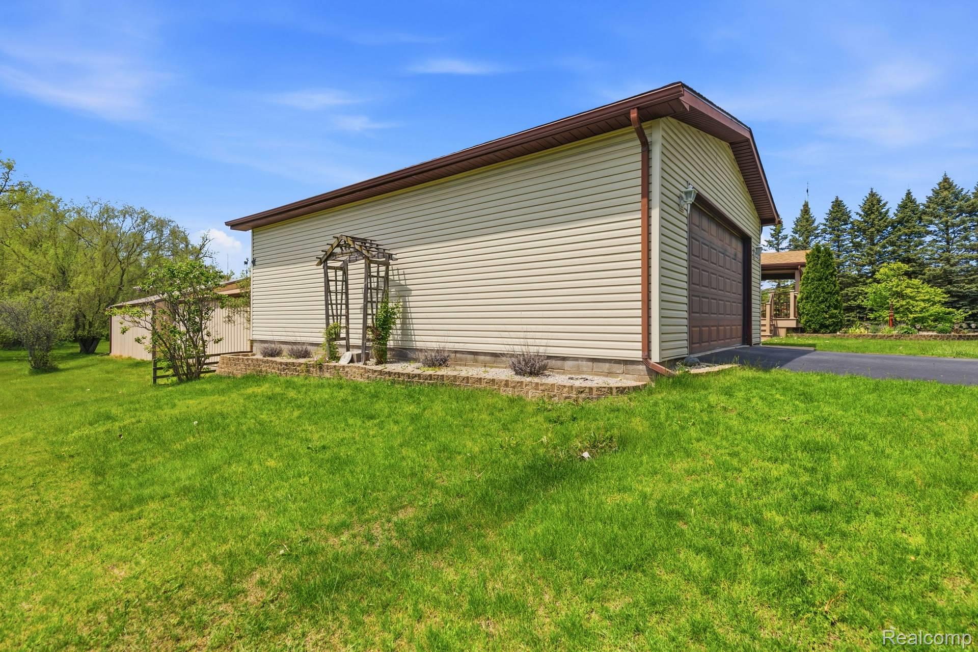 70919 Coon Creek Road Armada, MI 48005 - Photo 39 of 50 View of home's exterior featuring a yard and a garage