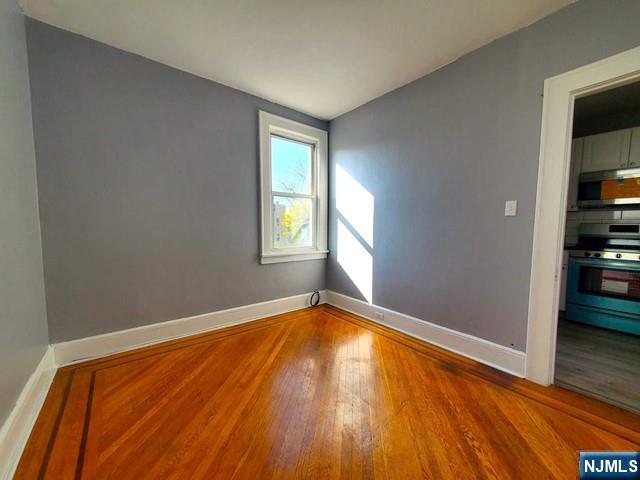 145 Baldwin Street, Unit 2 Bloomfield, NJ 07003 - Photo 12 of 16 an empty room with wooden floor and windows
