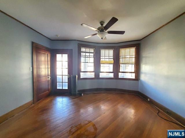 145 Baldwin Street, Unit 2 Bloomfield, NJ 07003 - Photo 4 of 16 an empty room with wooden floor and windows