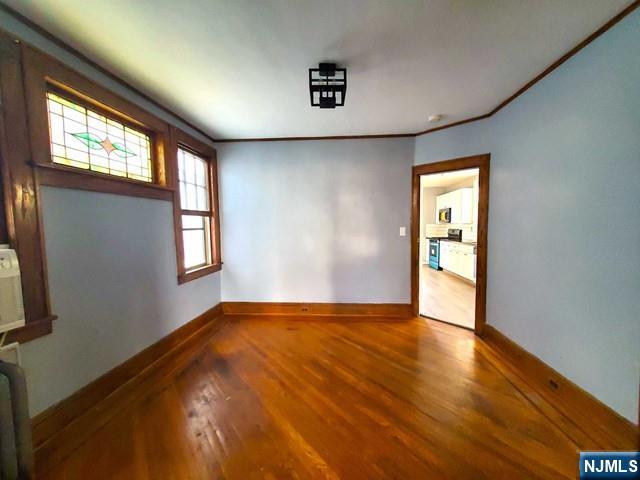 145 Baldwin Street, Unit 2 Bloomfield, NJ 07003 - Photo 7 of 16 a view of an empty room with a window and wooden floor