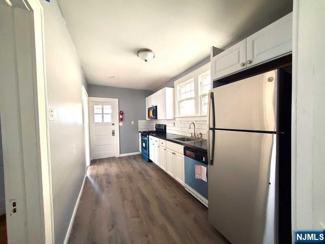 145 Baldwin Street, Unit 2 Bloomfield, NJ 07003 - Photo 8 of 16 a kitchen with sink a refrigerator and white cabinets