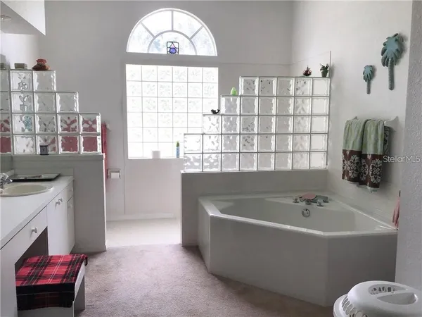 a bathroom with a tub a sink and a window