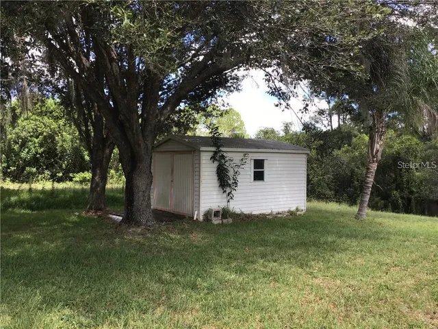 a view of a house in a yard with large tree