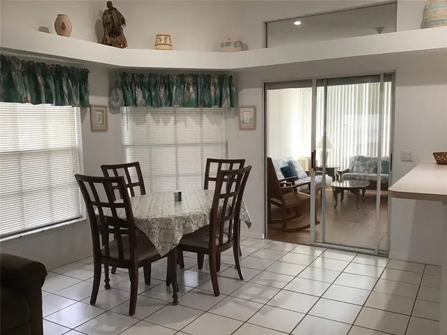 a dining area with furniture and a large window