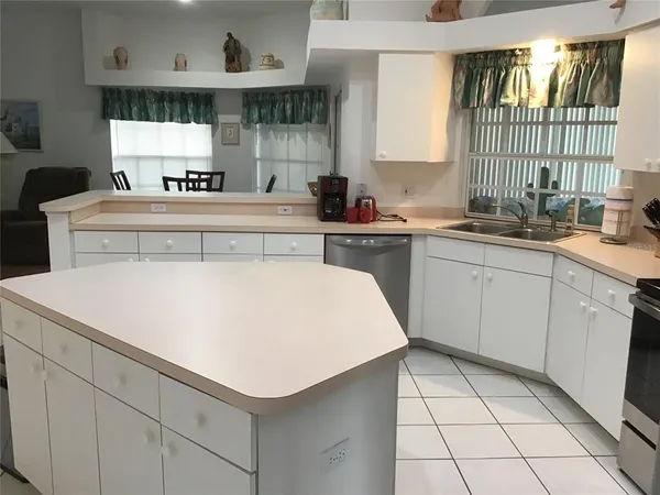 a kitchen with a sink a stove cabinets and counter space