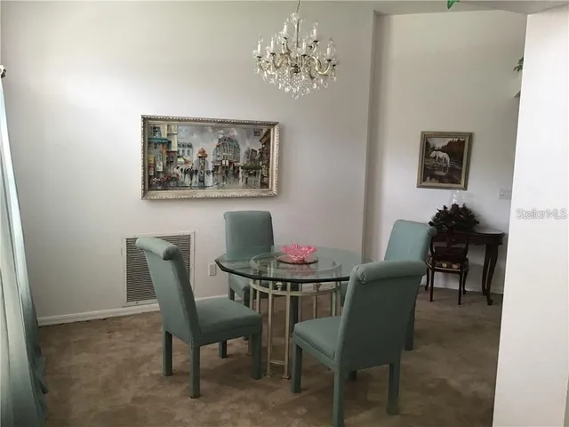 a view of a dining room with furniture and chandelier