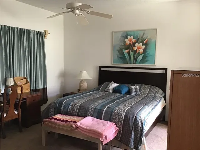 a bedroom with a bed and a painting on the wall