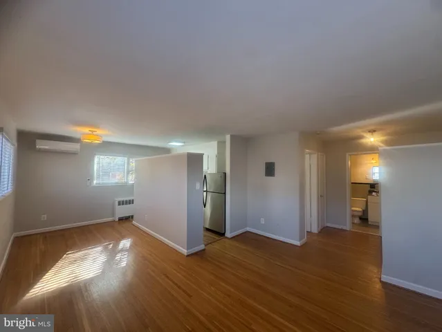 a view of empty room with wooden floor